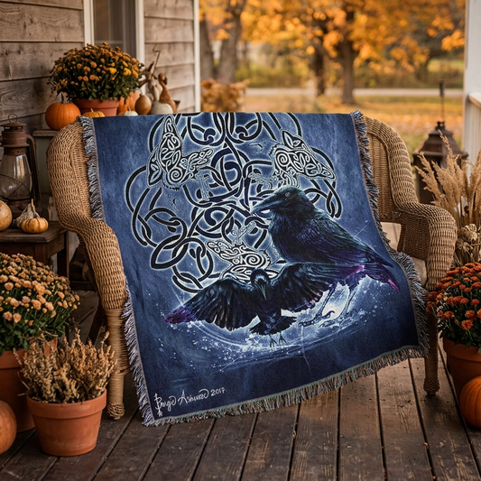 A square woven throw blanket with fringed edges, featuring a dark blue and black Celtic knot design with two raven birds in the center. The blanket is displayed flat against a solid white background.