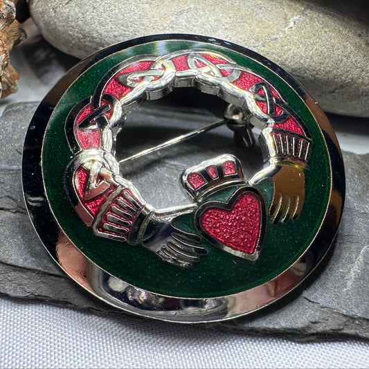 A Claddagh ring with two hands holding a crowned heart