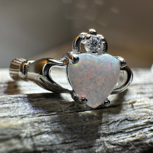 A Claddagh ring worn on a hand, showing the heart, hands, and crown