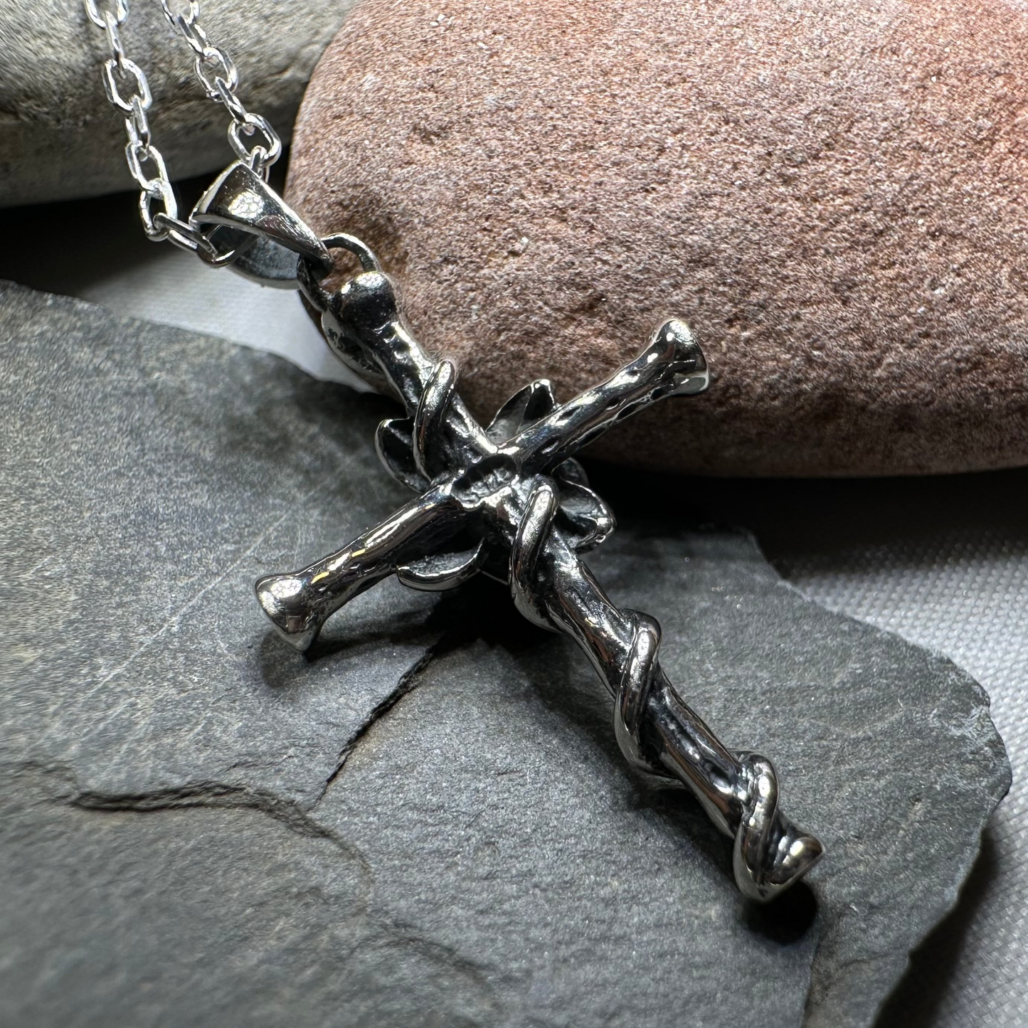 Silver crucifix necklace on a stone surface