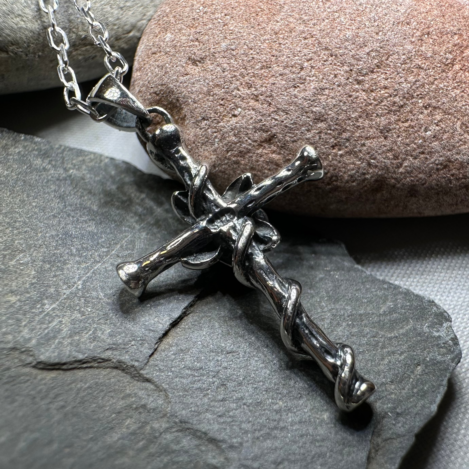 Silver crucifix necklace on a stone surface